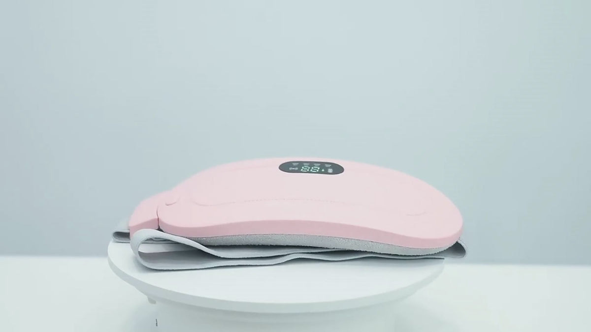 Ceinture chauffante SwissTouch rose en démonstration, écran digital affichant la température et sangle grise ajustable